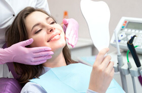 cosmetic dental patient holding hand mirror