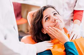 Woman with toothache visiting her Woodbridge emergency dentist