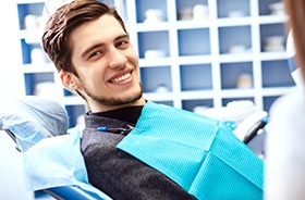 Smiling young man in dental treatment chair